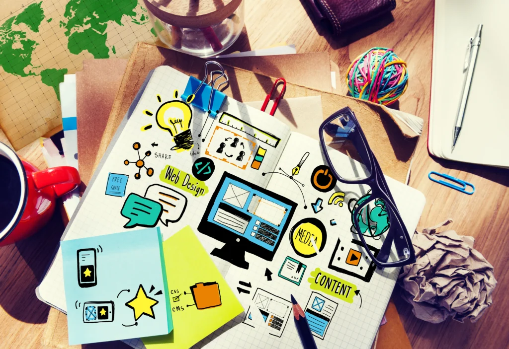 Creative web design planning sketch with UI elements, branding concepts, and digital content layout ideas on a notebook